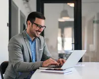 person sitting at a table on a laptop